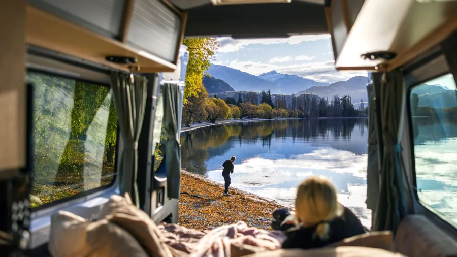 View from inside a Maui campervan parked beside Lake Wānaka during autumn