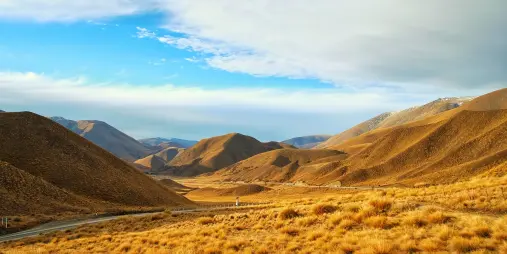 Scenic view of Lindis Pass with golden tussock hills between Cromwell and Omarama