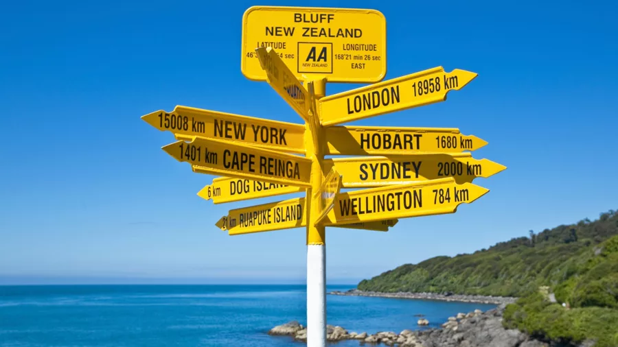 Famous Stirling Point signpost in Bluff, Southland, New Zealand showing distances to cities around the world