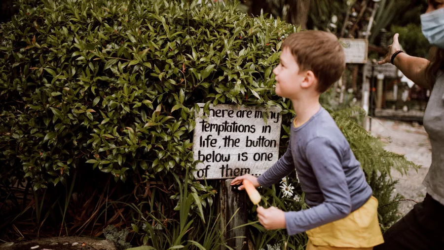 Child reading quirky sign at The Lost Gypsy in Papatowai