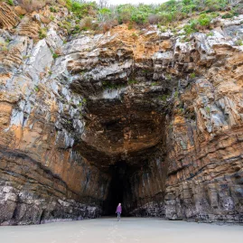 Person standing at the entrance of Cathedral Caves in The Catlins, Southland, New Zealand