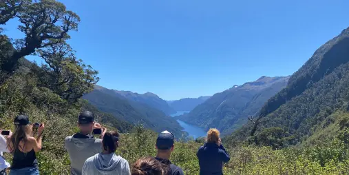 Travellers admiring the scenic view of Doubtful Sound from Wilmot Pass in Southland, New Zealand