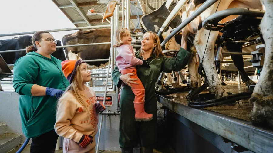 Family enjoying a hands-on dairy farm tour in Gore, Southland, New Zealand