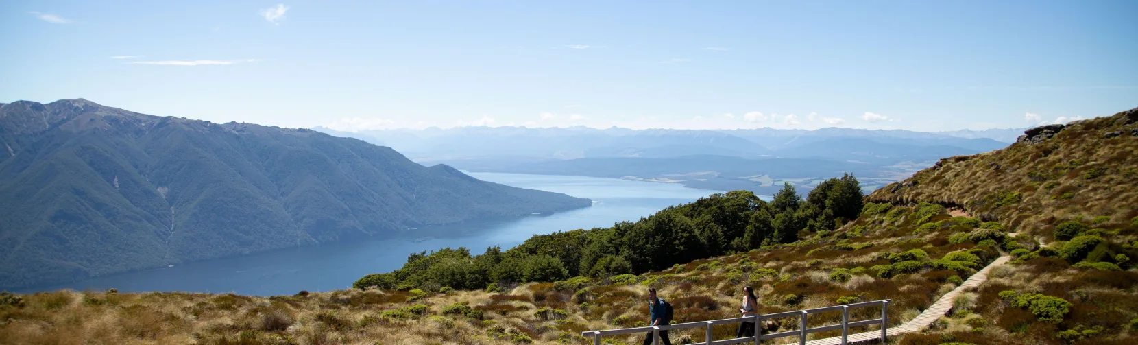 Hikers on a boardwalk overlooking Lake Te Anau on the Kepler Track, Southland, New Zealand
