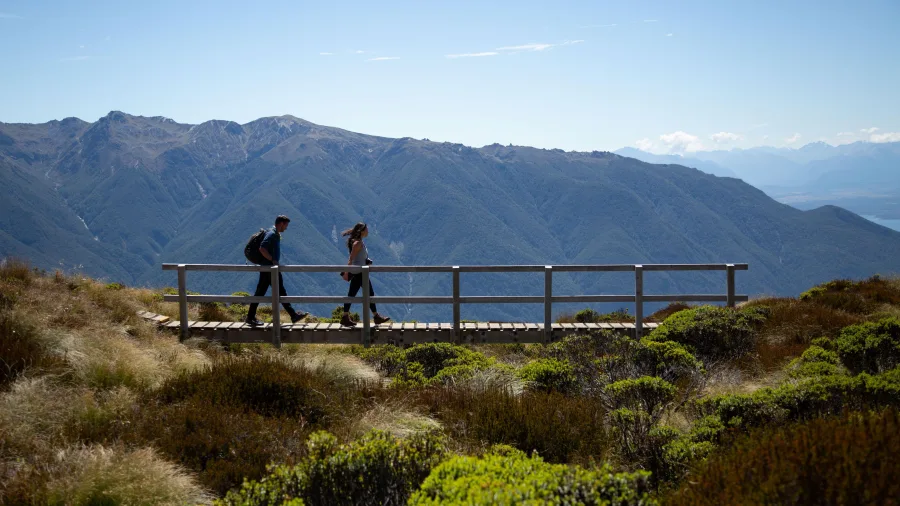 Couple hiking an alpine boardwalk on the Kepler Track, Southland, New Zealand