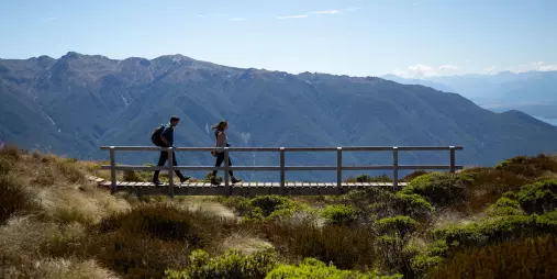 Couple hiking an alpine boardwalk on the Kepler Track, Southland, New Zealand