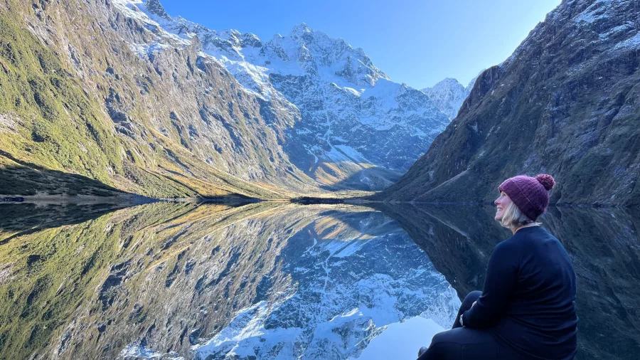 Perfect reflection of snow-capped mountains in still waters of Lake Marian, Fiordland National Park, Southland New Zealand