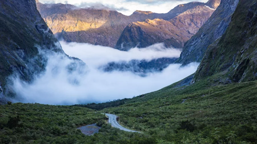 Mist rolling through a mountain valley along Milford Road in Southland, New Zealand