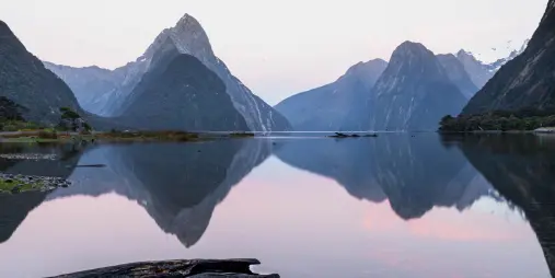 Sunrise view of Mitre Peak reflected in the calm waters of Milford Sound, Fiordland National Park, South Island, New Zealand.