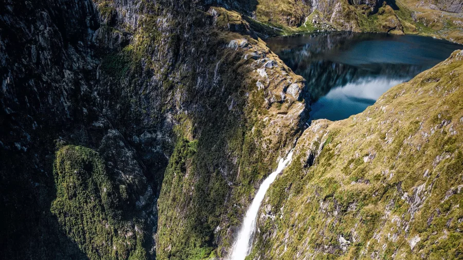 Aerial view of Sutherland Falls cascading into a valley in Fiordland National Park, New Zealand