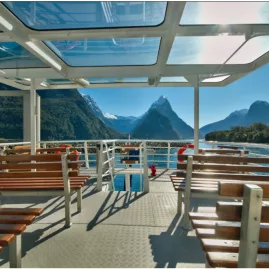 Open-air upper deck on the Milford Adventurer with views of Mitre Peak in Milford Sound.