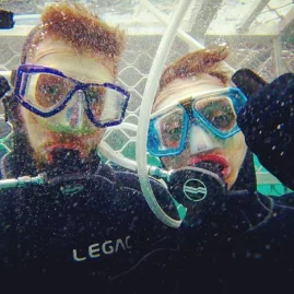 Two divers pose inside a shark cage during a great white shark tour in New Zealand