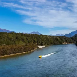Jet boat travelling through remote Waiau  River scenery in Fiordland National Park.