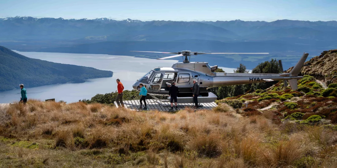 Helicopter landing on the Kepler Track ridgeline for a guided alpine hike.