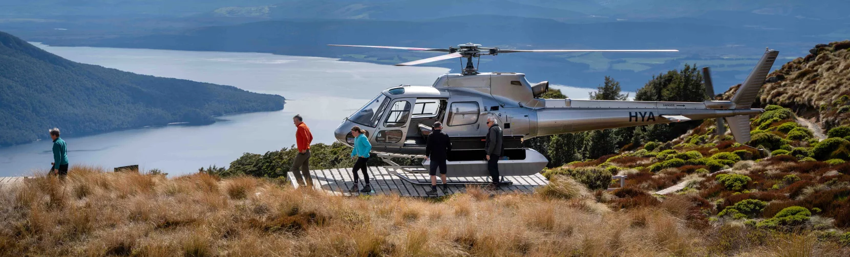 Helicopter landing on the Kepler Track ridgeline for a guided alpine hike.