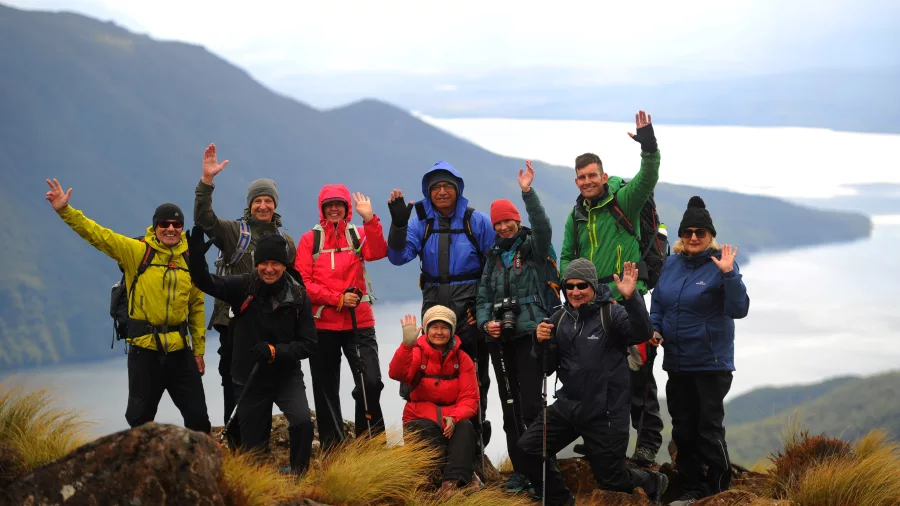 Smiling group of walkers posing on the Kepler Track summit.
