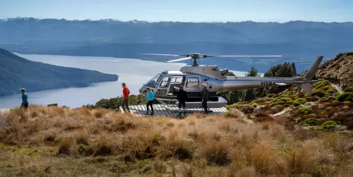 Helicopter landing on the Kepler Track ridgeline for a guided alpine hike.