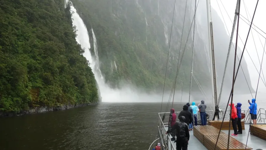 Guests aboard the MV Milford Mariner cruise near Stirling Falls in Milford Sound.