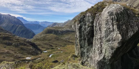 Rock outcrop overlooking an alpine valley on the Routeburn Track, New Zealand