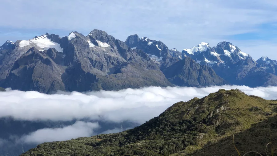 Snow-capped mountain range above the clouds on the Routeburn Track, New Zealand