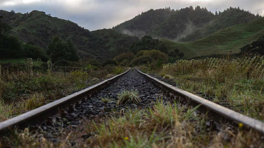 Disused rail track winding through green hills on the Forgotten World Highway