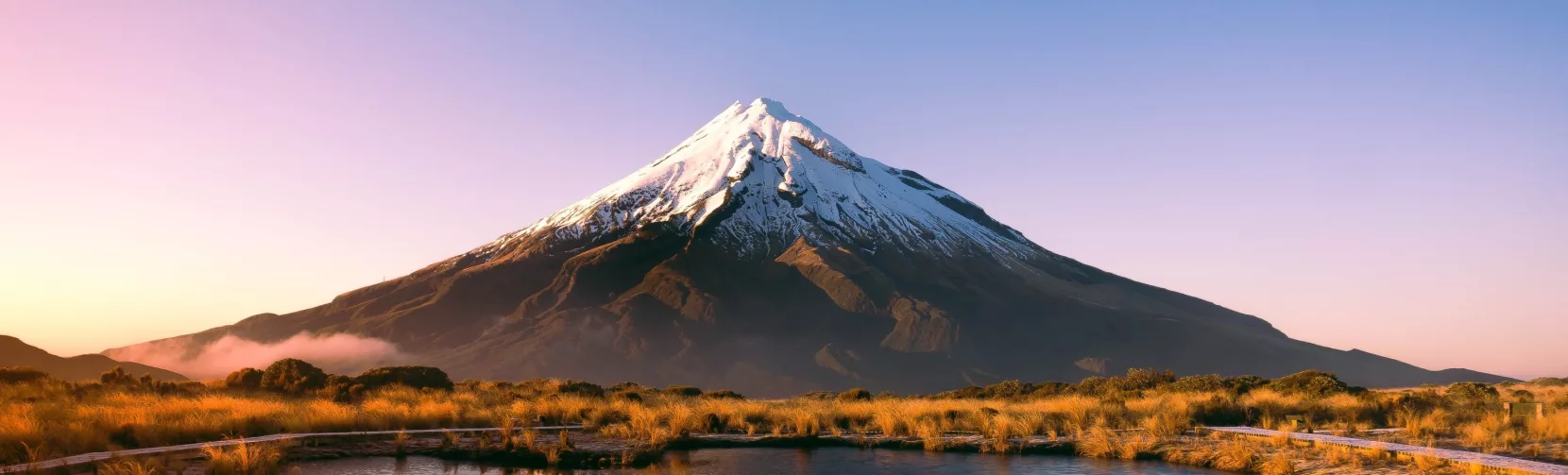 Mount Taranaki reflecting in Pouākai Tarn at sunrise in Egmont National Park