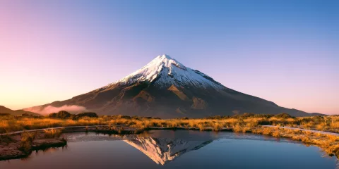 Mount Taranaki reflecting in Pouākai Tarn at sunrise in Egmont National Park