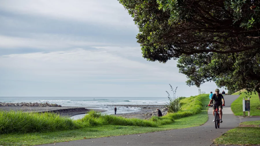 Cyclists riding along the Coastal Walkway in New Plymouth with ocean views nearby