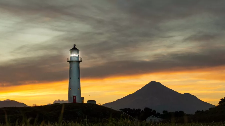 Cape Egmont Lighthouse with Mount Taranaki silhouetted at dawn