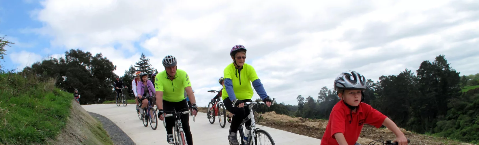 Family group cycling uphill on the Te Awa River Ride near Cambridge