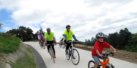 Family group cycling uphill on the Te Awa River Ride near Cambridge