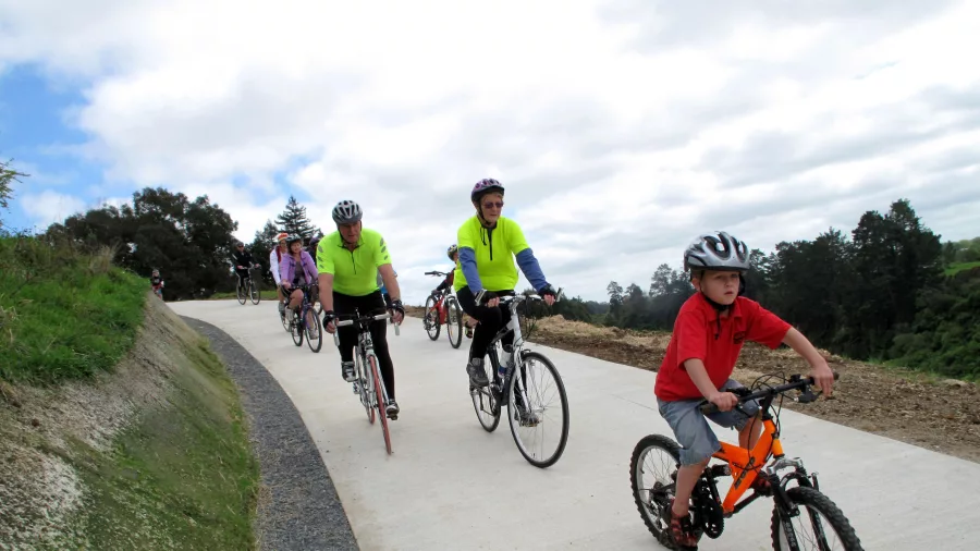 Family group cycling uphill on the Te Awa River Ride near Cambridge