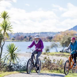 Friends cycling together along the Great Lake Walkway at Five Mile Bay, Taupō lakefront