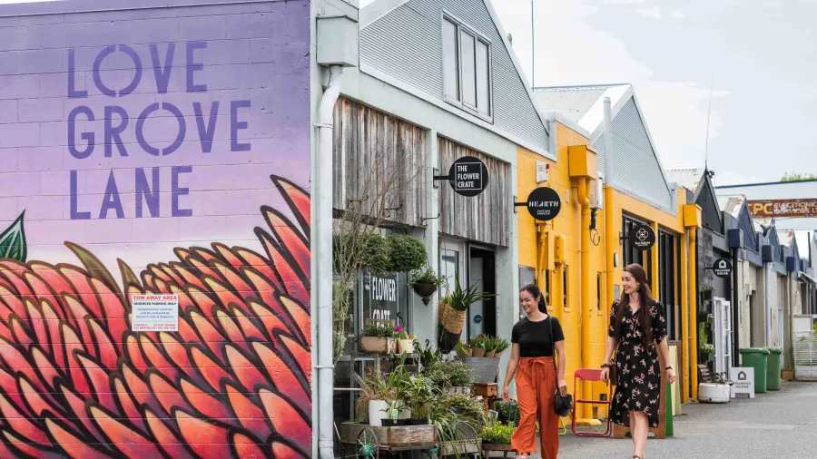 Visitors walking past boutique shops and street art at Love Grove Lane in Hamilton, Waikato, New Zealand.