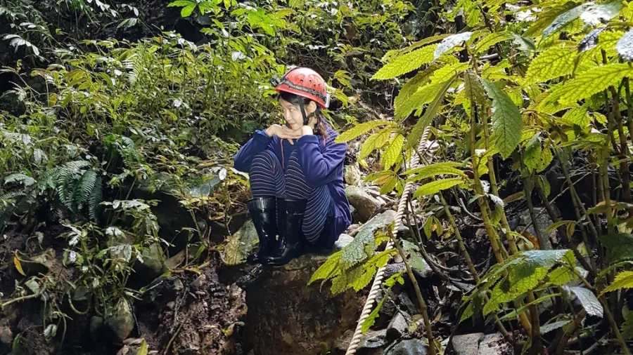 Guest in caving gear taking a break during a Glowing Adventures private tour in the Waitomo forest