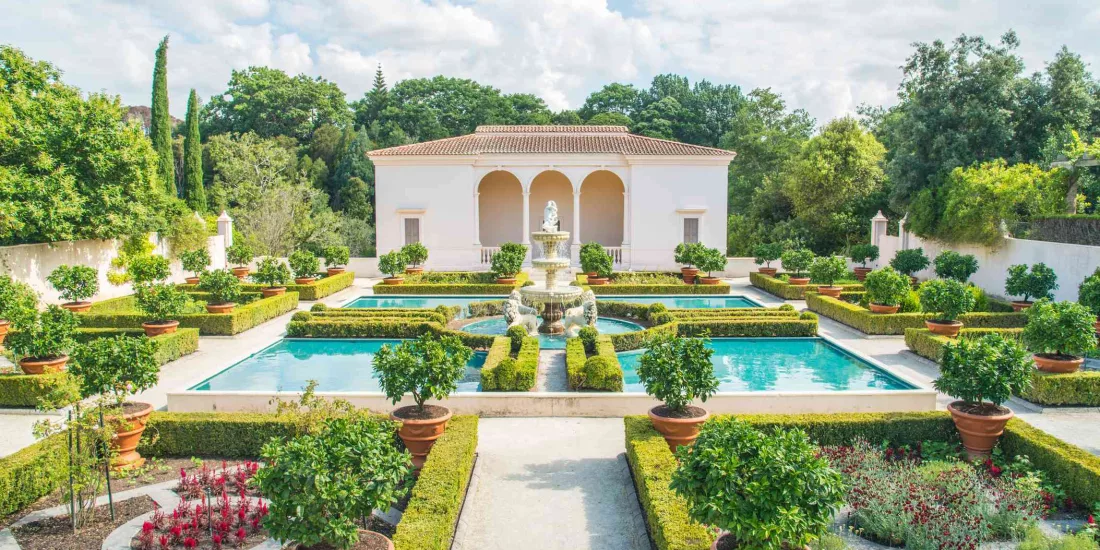 Aerial view of the Italian Renaissance Garden at Hamilton Gardens showing symmetrical pools, potted citrus trees, and formal landscaping in New Zealand