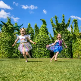 Children dressed in costumes running through the Surrealist Garden at Hamilton Gardens in Waikato