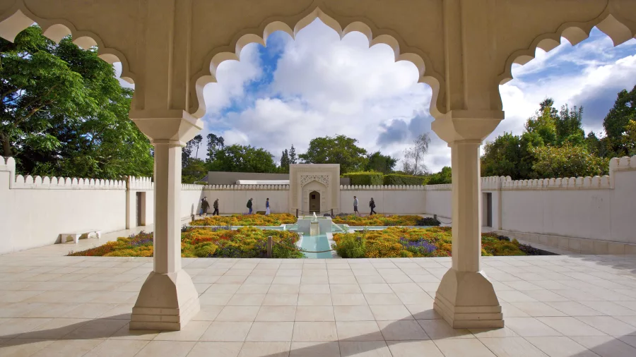 View of the Indian Char Bagh Garden at Hamilton Gardens, featuring symmetrical flower beds, white pavilion, and flowing water channels inspired by Mughal design
