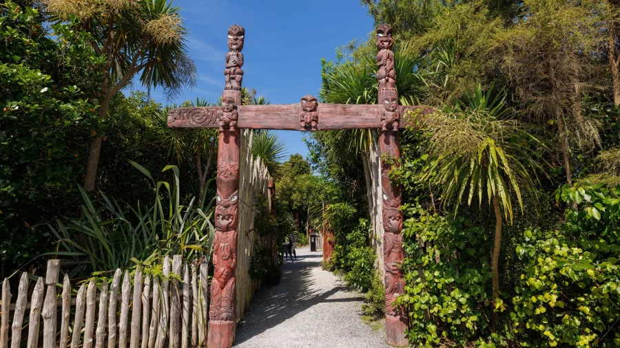 Carved Māori gateway at Te Parapara Garden in Hamilton Gardens, surrounded by native New Zealand plants