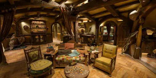 Interior of a Hobbit hole in Bagshot Row with rustic wooden furniture and warm lighting