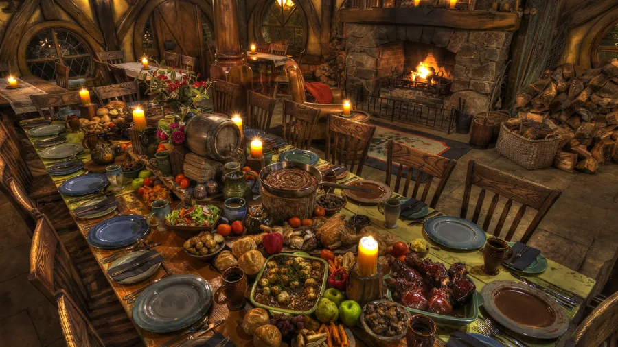 Banquet table at Hobbiton Movie Set with candlelight, food, and rustic decor inside a hobbit hole