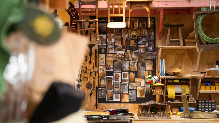Wall of woodwork references and Hobbiton miniatures inside the film props workshop