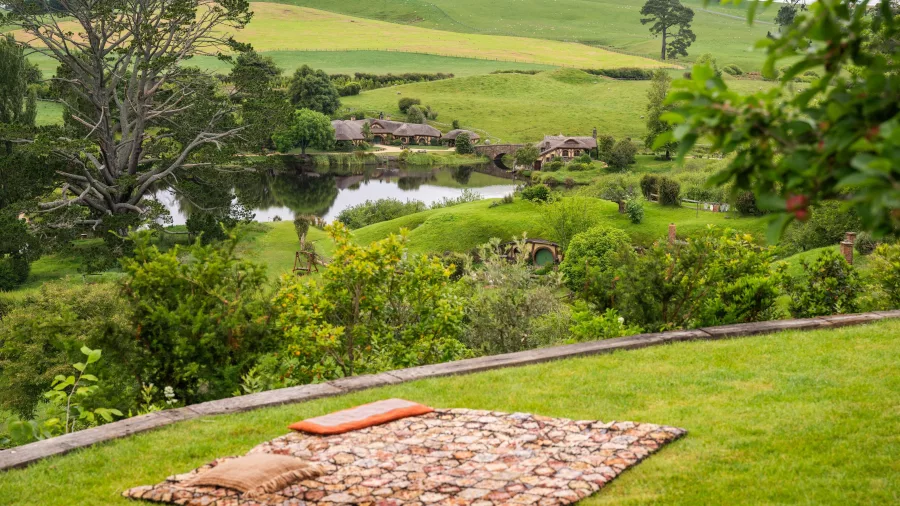 View of Hobbiton with picnic blanket in the foreground and Green Dragon Inn in the distance