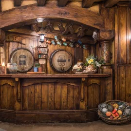 Rustic bar inside the Green Dragon Inn at Hobbiton Movie Set with wooden barrels and mugs hanging above