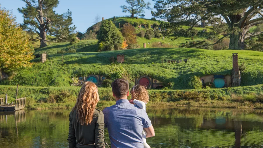 Family standing by the lake admiring the view of Hobbit Holes at Hobbiton