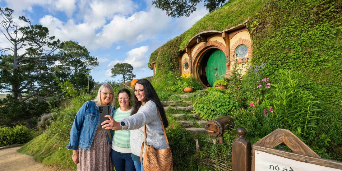Group of women taking a selfie outside Bag End with the green round door