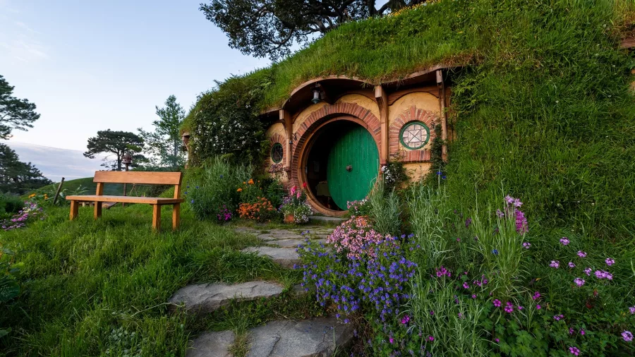 Bag End Hobbit Hole with green round door surrounded by colourful flowers