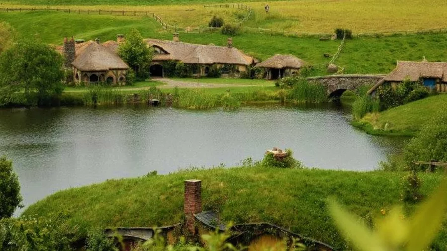 Hobbiton Movie Set with hobbit holes, The Green Dragon Inn and lake in Matamata, Waikato New Zealand