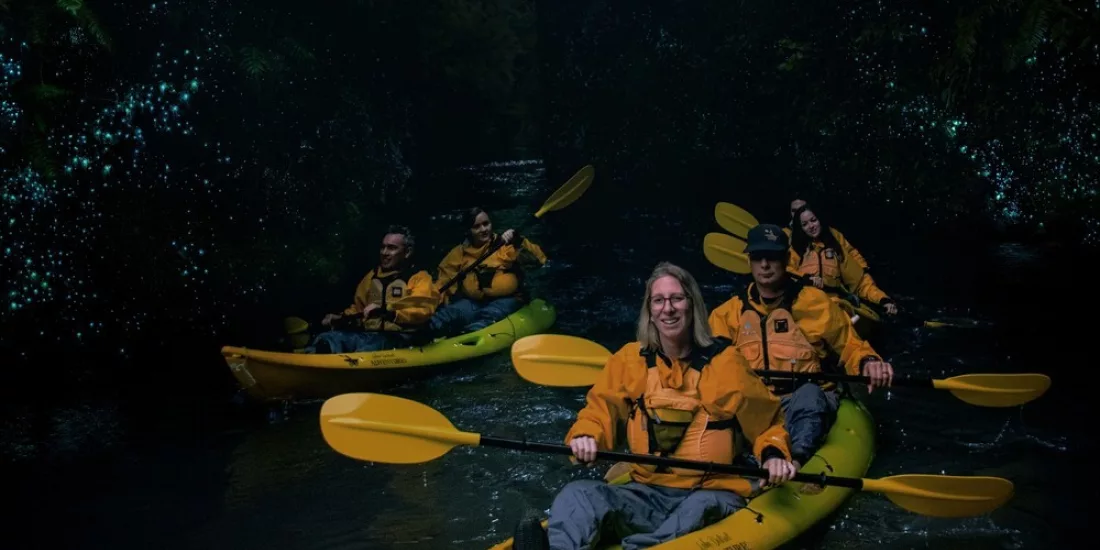 Group kayaking through glowworm-lit canyon on a Full Day Private Adventure with Riverside Adventures