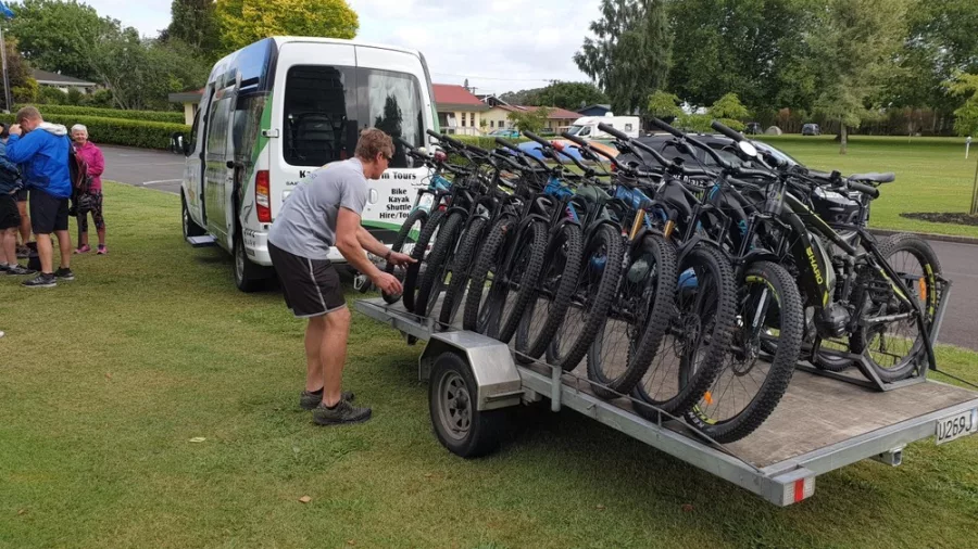 Bikes lined up on a trailer attached to a Riverside Adventures shuttle van